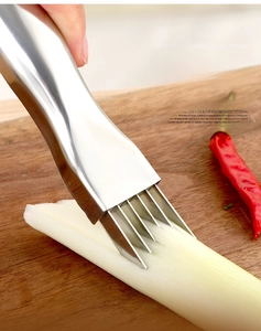 Detail of multi-blade stainless steel scallion shredder slicing green onion on wood