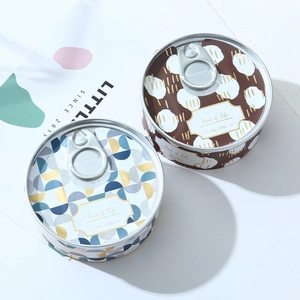 Detail of two decorative tinplate soy wax candles with pull-tab lids and geometric patterns