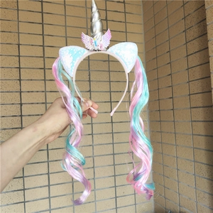Macro detail of unicorn headband with sequin ears and colorful gradient hair extensions