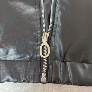 Détail du zip métallique argenté et de l'ourlet élastique sur veste motard en cuir