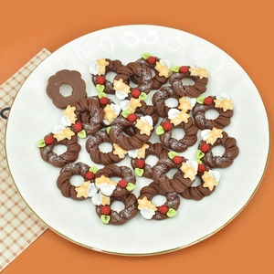 Macro view of miniature chocolate wreath donuts with tiny star and berry resin details