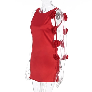 Detail of red satin mini dress featuring 3D handmade roses and side slit design