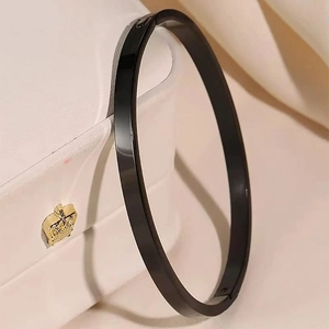 Close-up of polished black stainless steel bangle with a secure clasp mechanism