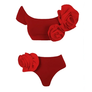Detail view of red two-piece swimsuit with large 3D rose floral decorations and high waist