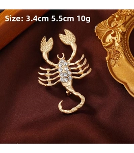 Detail view of gold scorpion brooch with white rhinestones, size 3.4cm x 5.5cm shown