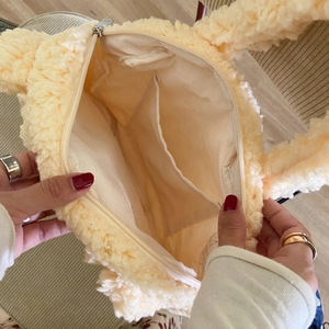 Detail of the plush lamb wool bag interior showing canvas lining and inner pocket
