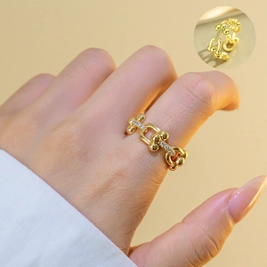 Macro detail of U-shaped gold ring with pavé zircons and polished chain design link