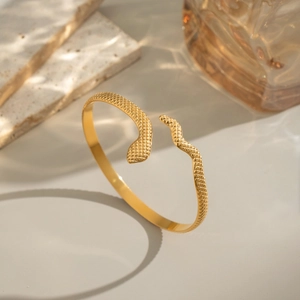 Detail shot of the gold snake bracelet showcasing intricate scale textures and metallic finish