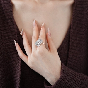 Gros plan d'une bague fleur en argent ornée de diamants sur la main d'un mannequin