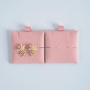 Detailed view of floral pearl earrings on pink velvet jewelry inserts in high quality