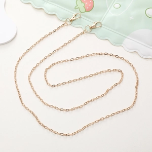 Detail of a shiny gold metal DIY phone case strap with lobster clasps on a white background