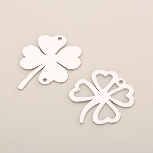 Detailed macro view of silver titanium steel clover pendants in solid and hollow heart designs