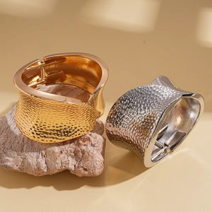 Irregular wrinkled hammered metal open bracelet in gold and silver finish on stones