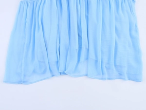 Detail view of light blue pleated chiffon fabric with high-quality stitching on the hemline