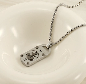 Gros plan sur le pendentif ancre rétro en acier inoxydable et sa chaîne carrée stylée