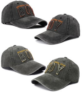 Close-up of vintage washed cotton baseball caps featuring BOY patch and urban embroidery