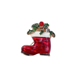 Detail of a red Christmas boot brooch with green leaves and red white crystals