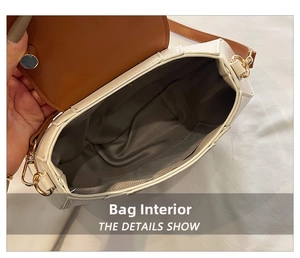 Interior view of the contrast handbag showing grey wavy lining and gold metal buckle