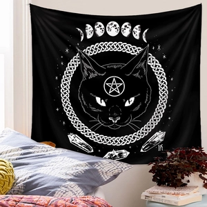 Detailed shot of mystic black cat tapestry with moon phases hanging in a cozy bedroom