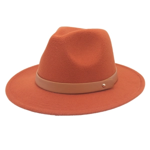 Détail d'un chapeau Fedora en feutre caramel avec ceinture en cuir et rivet doré chic