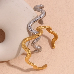Detail of 18K gold and silver plated bangles with hammered texture and wavy design
