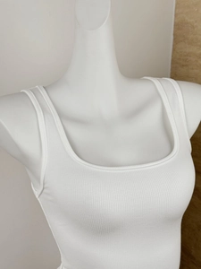 Detail von weißem geripptem Tanktop-Ausschnitt und Trägern auf einer Schaufensterpuppe