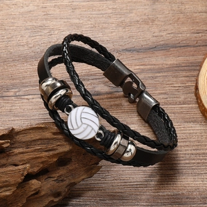 Detail of multi-layer black leather bracelet with metal beads and white volleyball charm