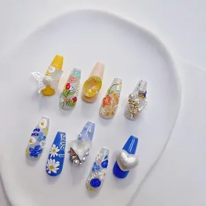 3D embossed floral press-on nails with blue and yellow colors and pearl butterfly charms