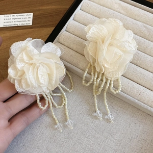 Detail of cream chiffon flower earrings with long beaded tassels and crystal accents