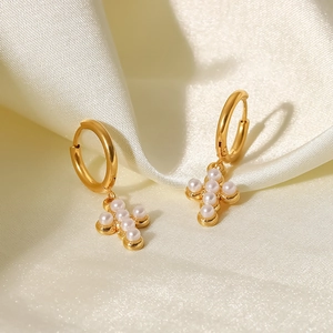 Detail of 18K gold stainless steel hoop earrings with cross pendant and white pearls