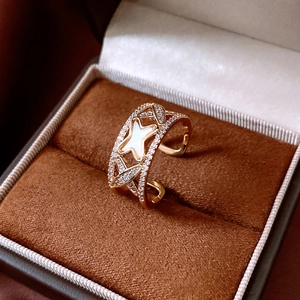 Detail of a gold butterfly ring with white mother-of-pearl and zircon in a velvet box