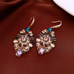 Luxurious vintage waterdrop earrings with colorful crystals on elegant dark silk backdrop