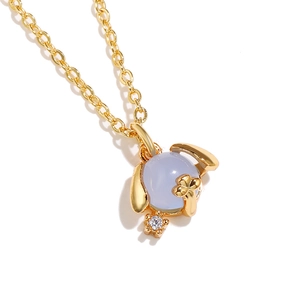 Macro shot of gold necklace with blue stone pendant and animal ear detail