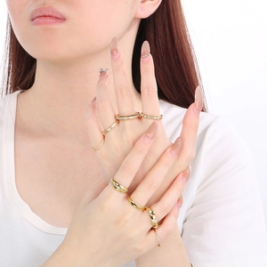 Detail of multiple 18K gold plated stainless steel rings with crystals on model's hand