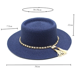 Détails d'un chapeau de paille avec chaîne dorée et glands montrant les dimensions