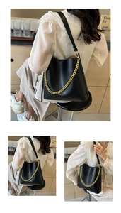 Detailed view of black leather tote bag with gold chain strap on model in cafe setting