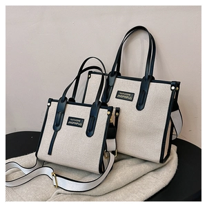 Close-up of contrast color canvas tote bags in two sizes with black leather straps