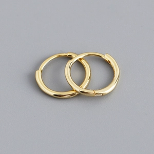 Detailed macro view of polished gold S925 sterling silver hoop earrings with huggie closure