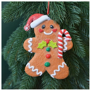 Macro detail of gingerbread man Christmas tree ornament with festive red hat and candy cane