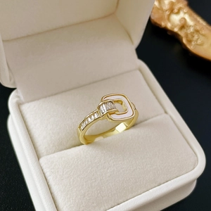 Golden geometric zircon ring with belt buckle design on white velvet jewelry box
