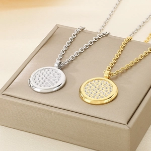 Macro detail of gold and silver circular pendants with pavé set crystals on a jewelry box