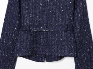 Detailaufnahme von dunkelblauem Tweed-Stoff mit feinen silbernen Pailletten und Textur