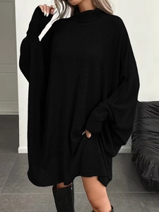 Detail of black turtleneck knit dress featuring vertical ribbed texture and batwing sleeves