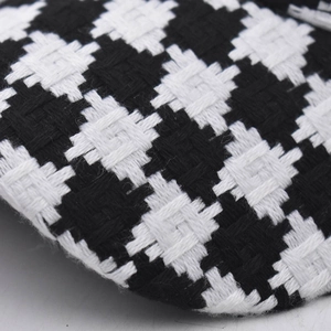 Detailed macro view of black and white houndstooth fabric texture on a baseball cap
