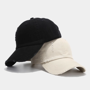 Distressed vintage baseball caps in black and beige with ripped details and a curved brim