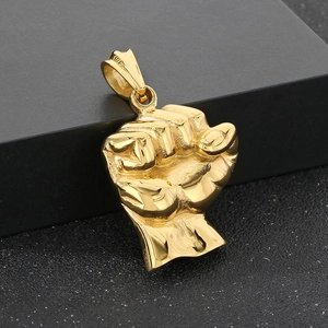 Detail shot of solid gold fist pendant with polished finish on a black gift box