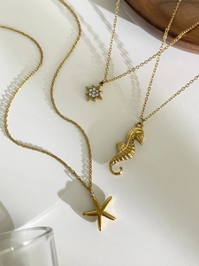 Détail des pendentifs étoiles de mer et hippocampes dorés avec incrustations de cristal