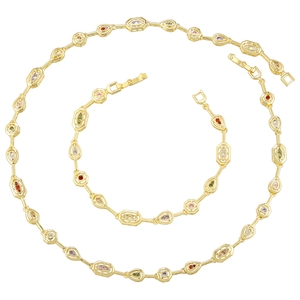 Macro shot of gold necklace and bracelet set with multi-shape links and colorful gemstones