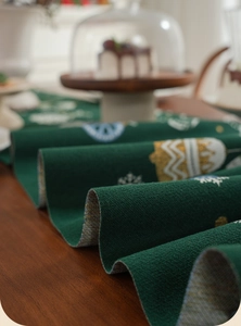 Close-up of thick green jacquard Christmas table runner with snowflake patterns