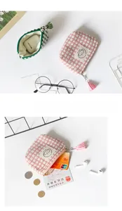 Detail of mini plaid coin purse with metal zipper and matching tassel for keys and earbuds